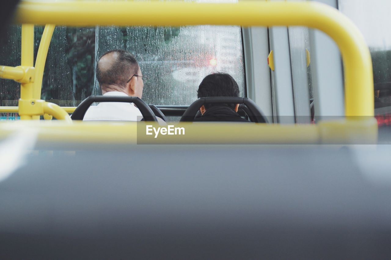 Rear view of men sitting in bus
