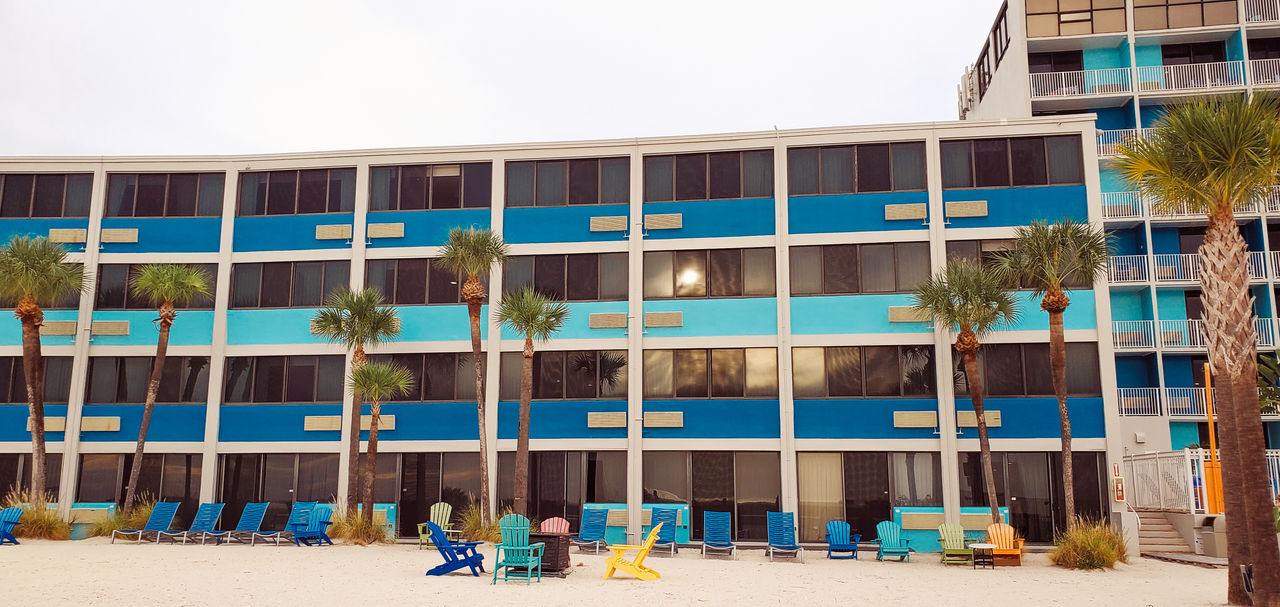 architecture, building exterior, built structure, building, nature, day, beach, city, land, sky, tropical climate, outdoors, facade, window, travel destinations, palm tree, sand