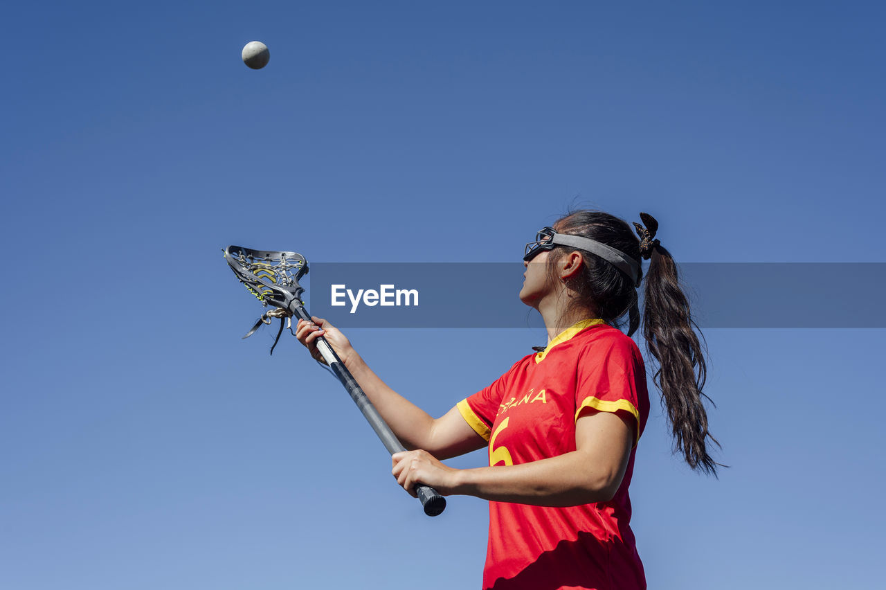 Athlete playing lacrosse under blue sky