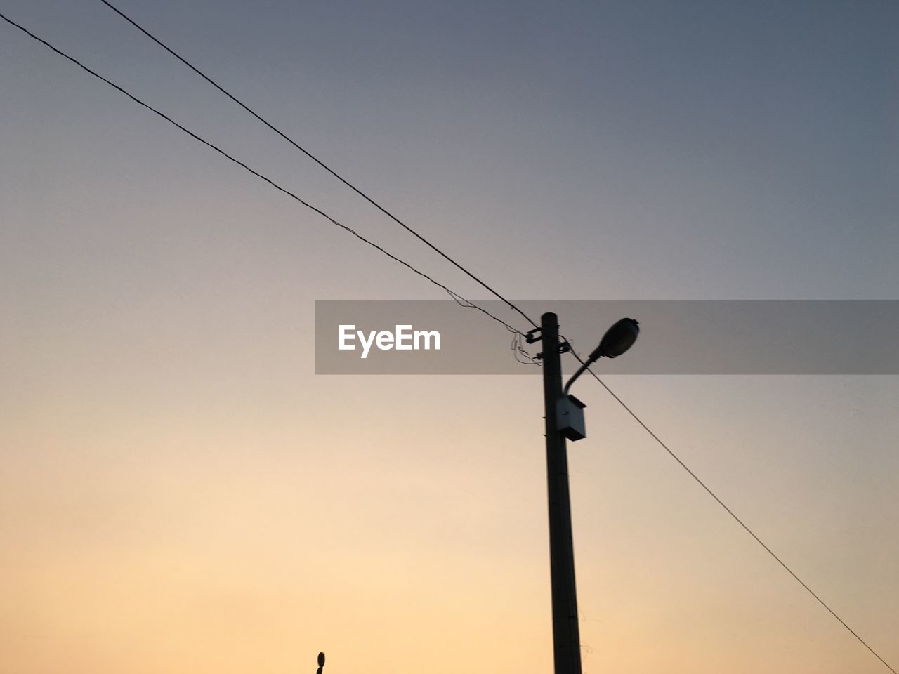 LOW ANGLE VIEW OF SILHOUETTE POWER LINES AGAINST CLEAR SKY