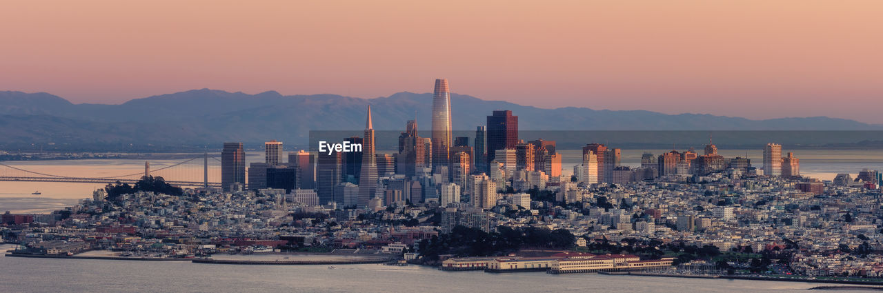 Panoramic view of city of san francisco by sea against sky