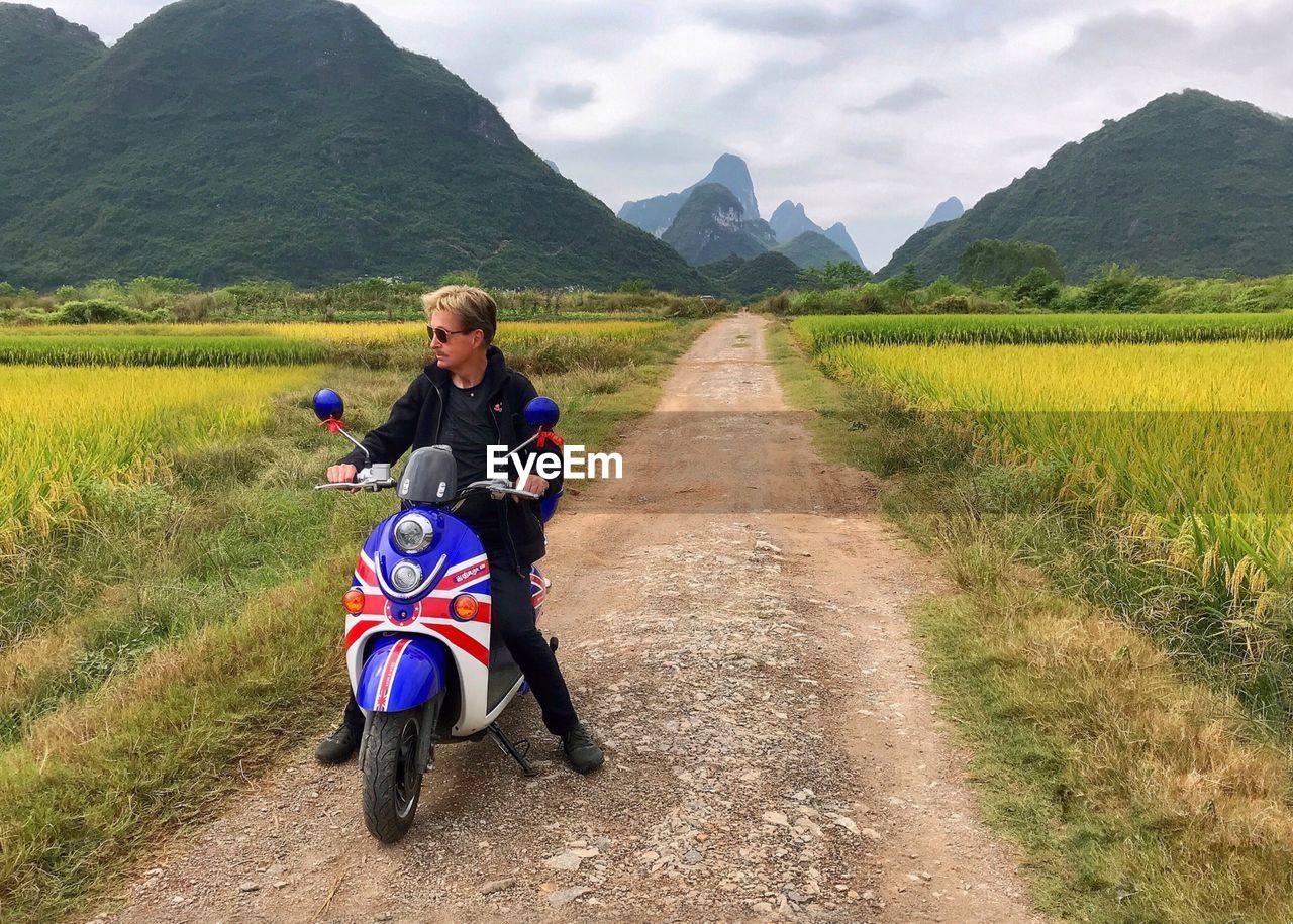 MAN RIDING MOTORCYCLE ON FIELD