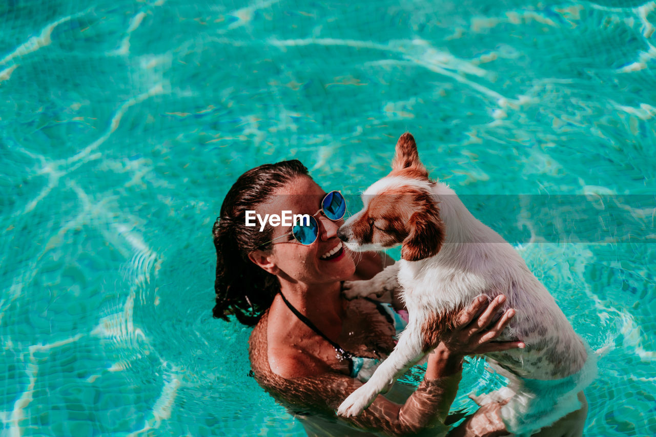 High angle view of woman with dog swimming in pool