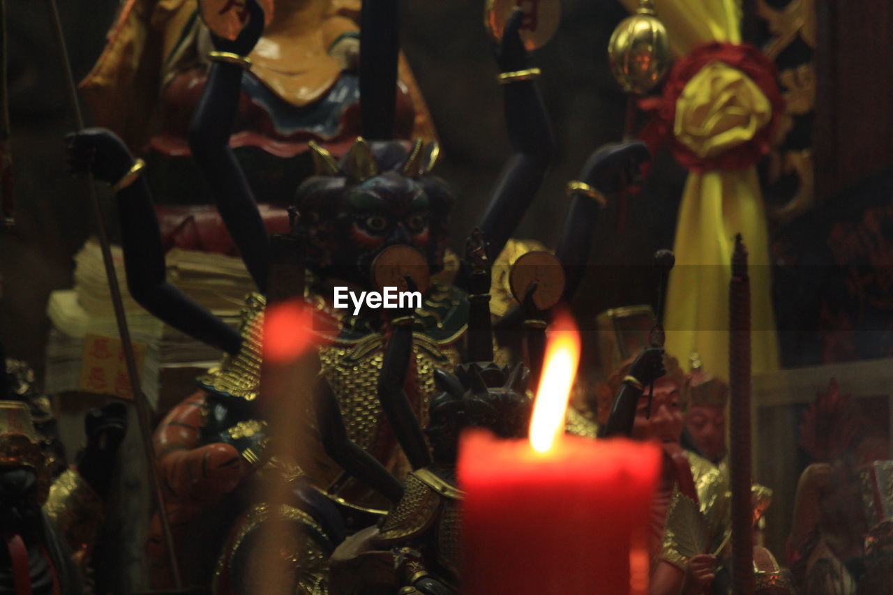 Close-up of illuminated candle in temple