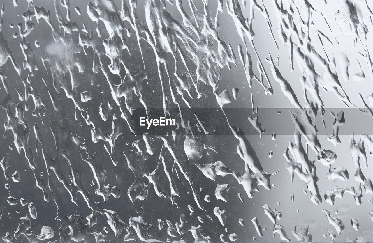 Drops of frozen water on the window glass in winter. abstract background or backdrop.