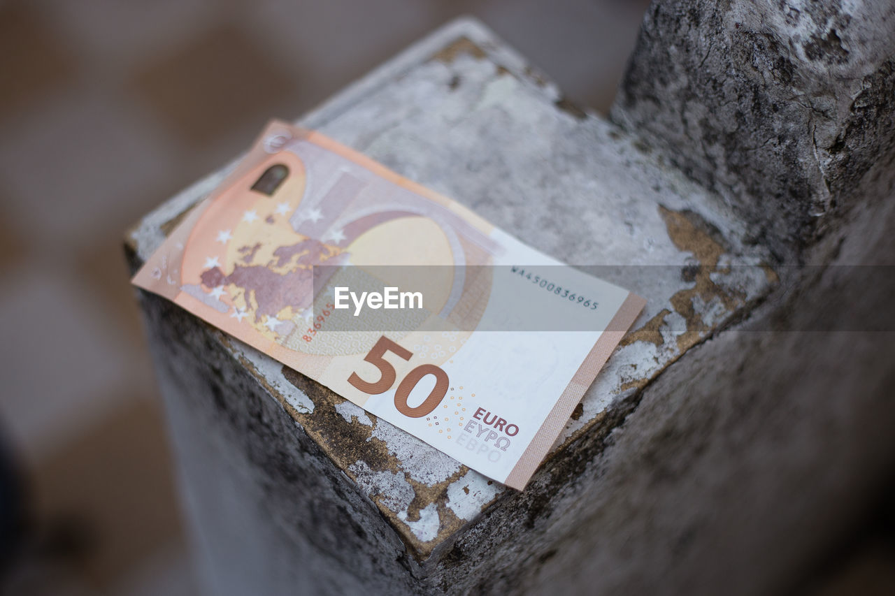 High angle view of paper currency on concrete