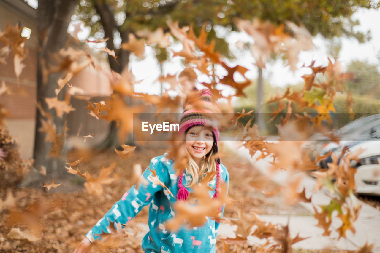 Portrait of smiling girl seen through leaves