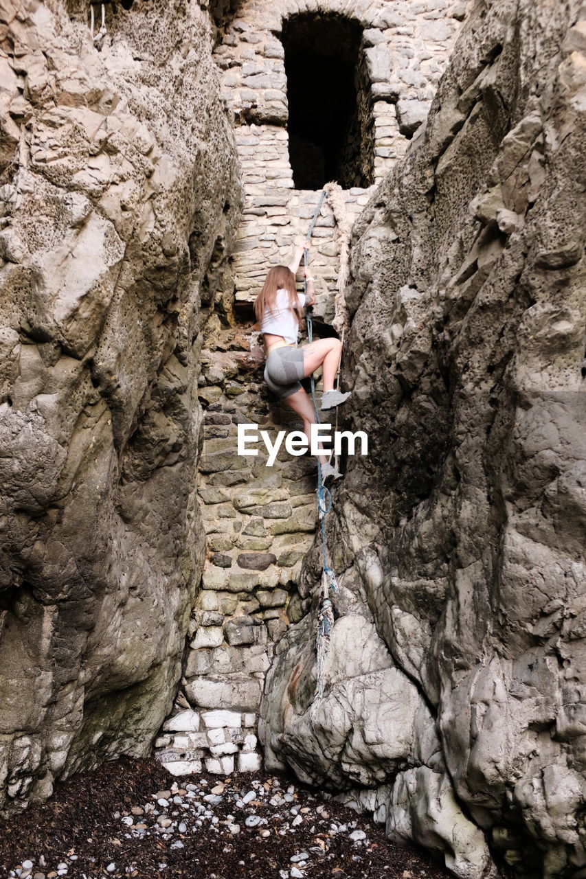 rear view of man climbing on rock