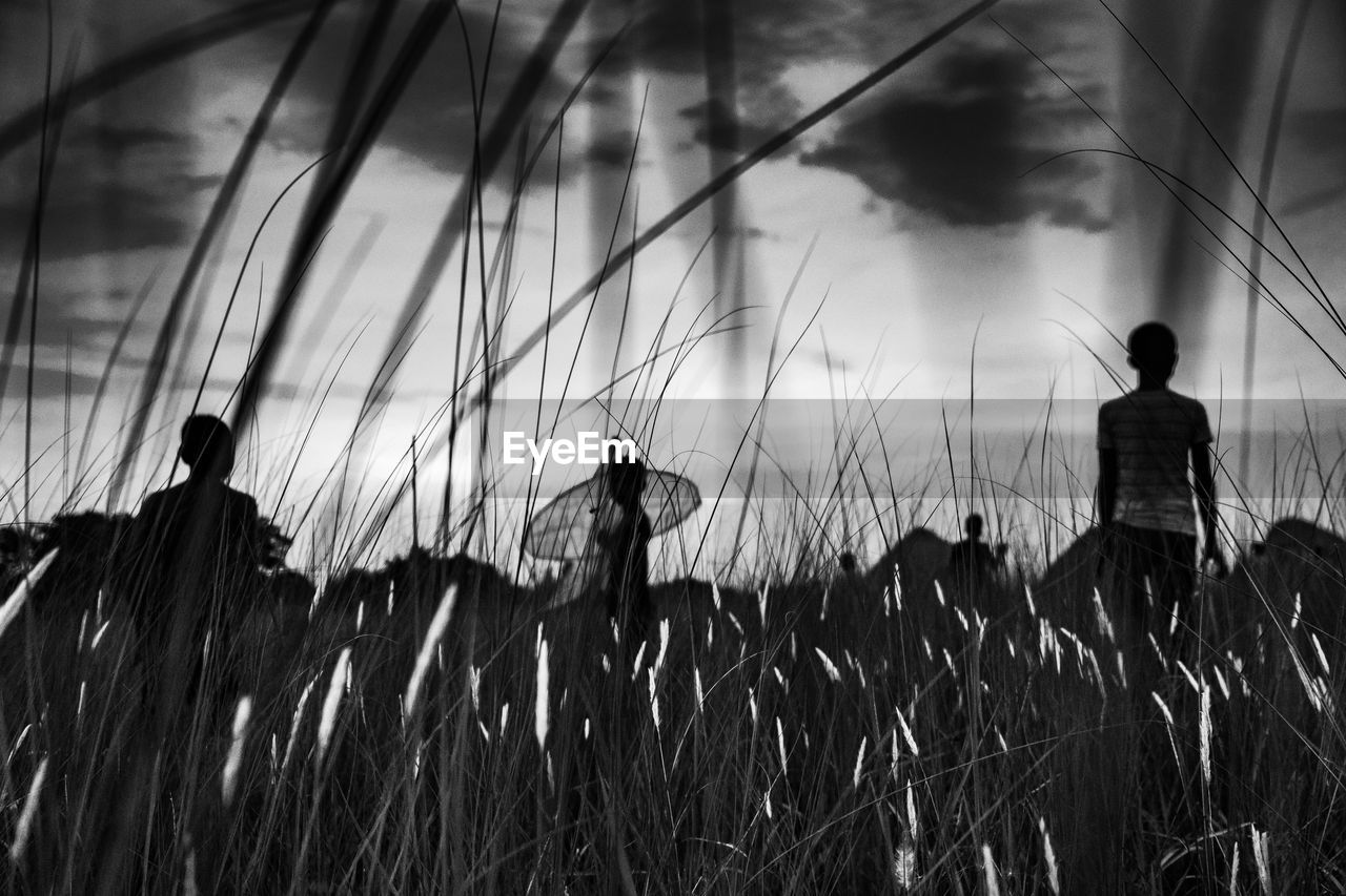 Rear view of silhouette man standing on field against sky