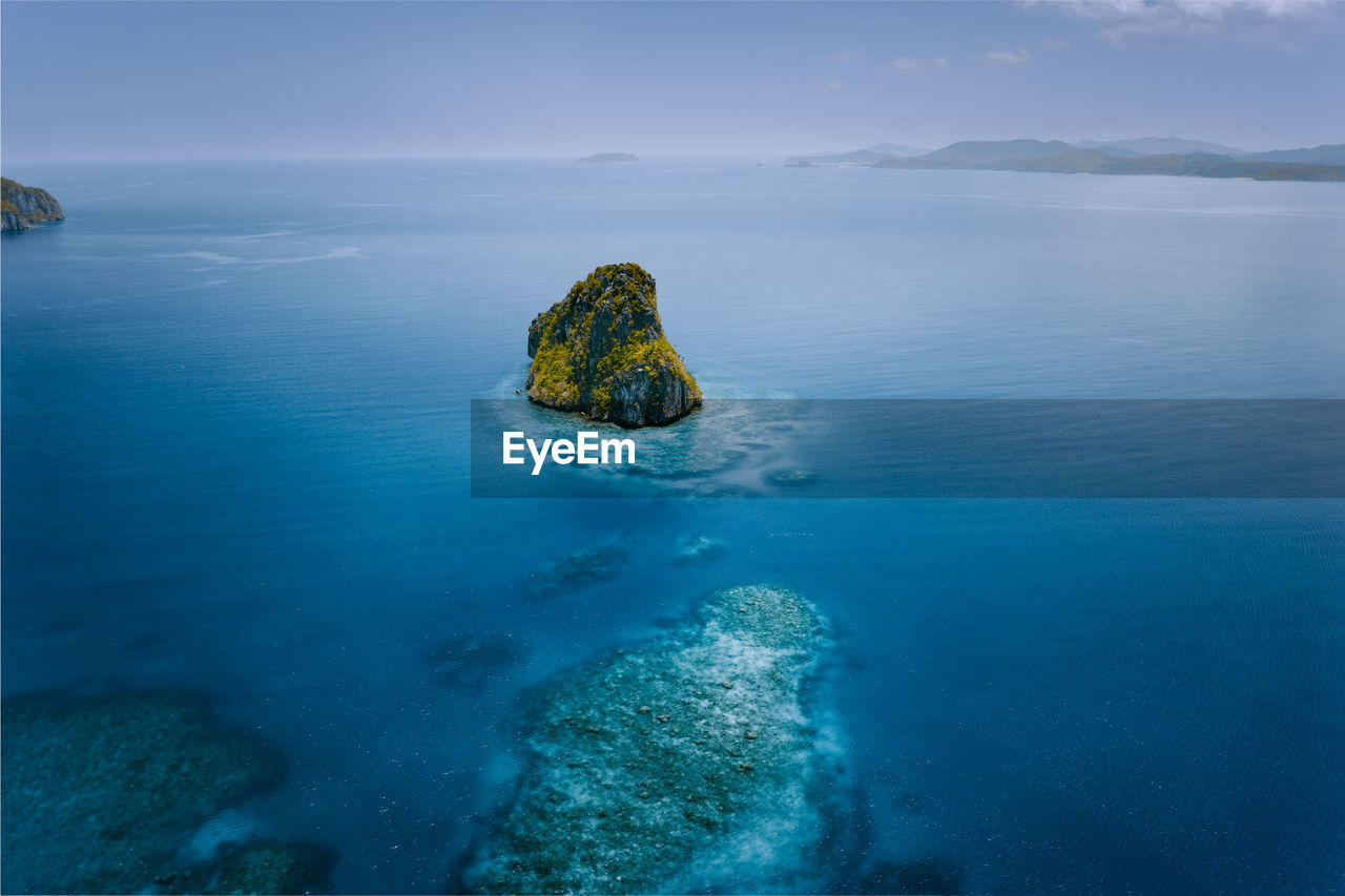 Scenic view of rock in sea against sky