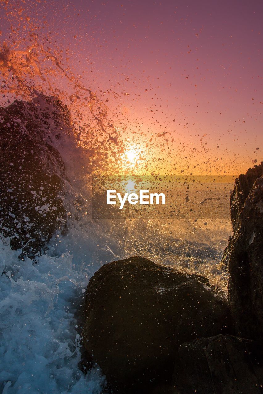 Close-up of sea against clear sky during sunset
