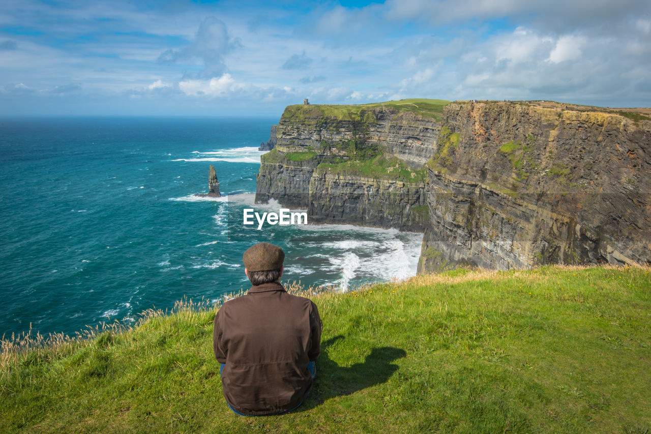 Rear view of man sitting at beach