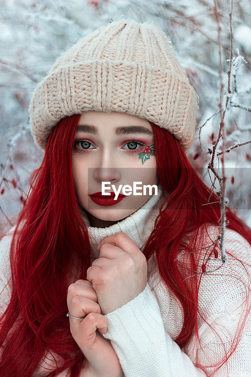 Portrait of redhead woman in hat outdoors during winter