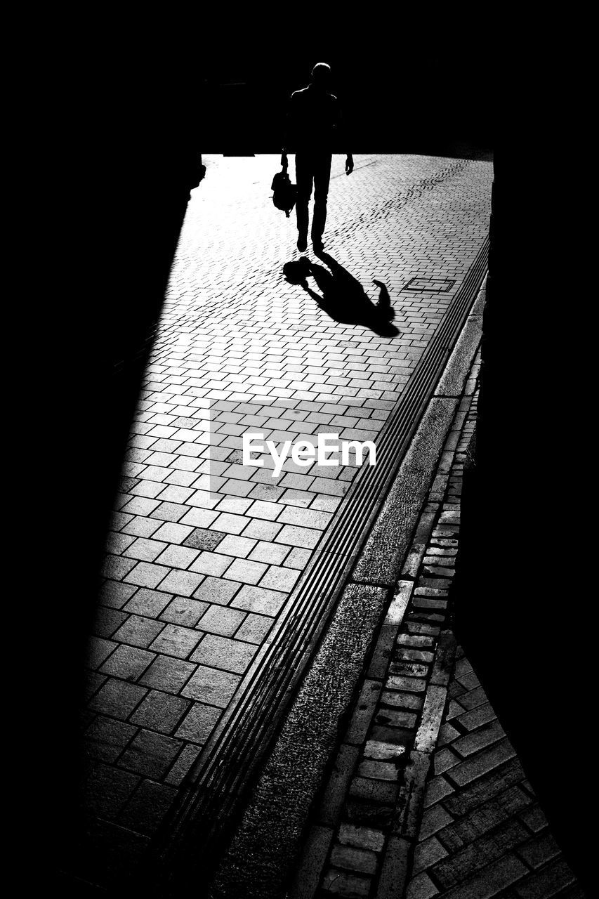 FULL LENGTH REAR VIEW OF SILHOUETTE MAN WALKING ON STREET