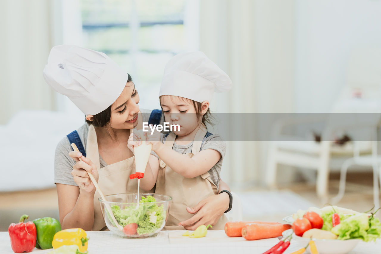 MIDSECTION OF WOMAN WITH ICE CREAM IN SHOP