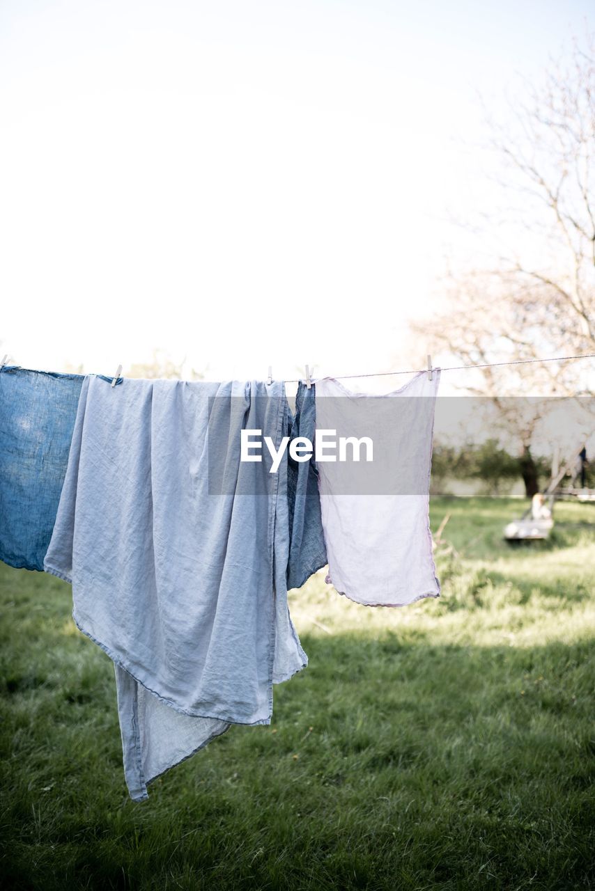 Laundry hanging on clothesline over grassy field