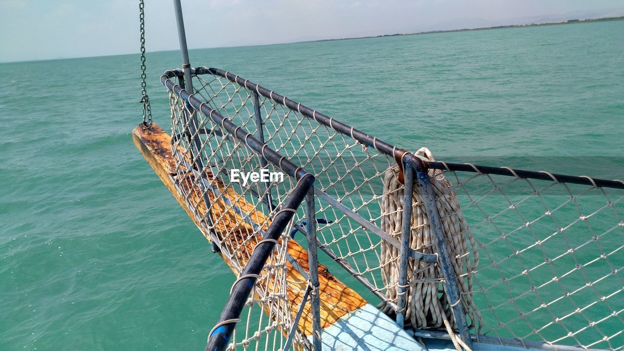 FISHING NET ON RAILING AGAINST SEA
