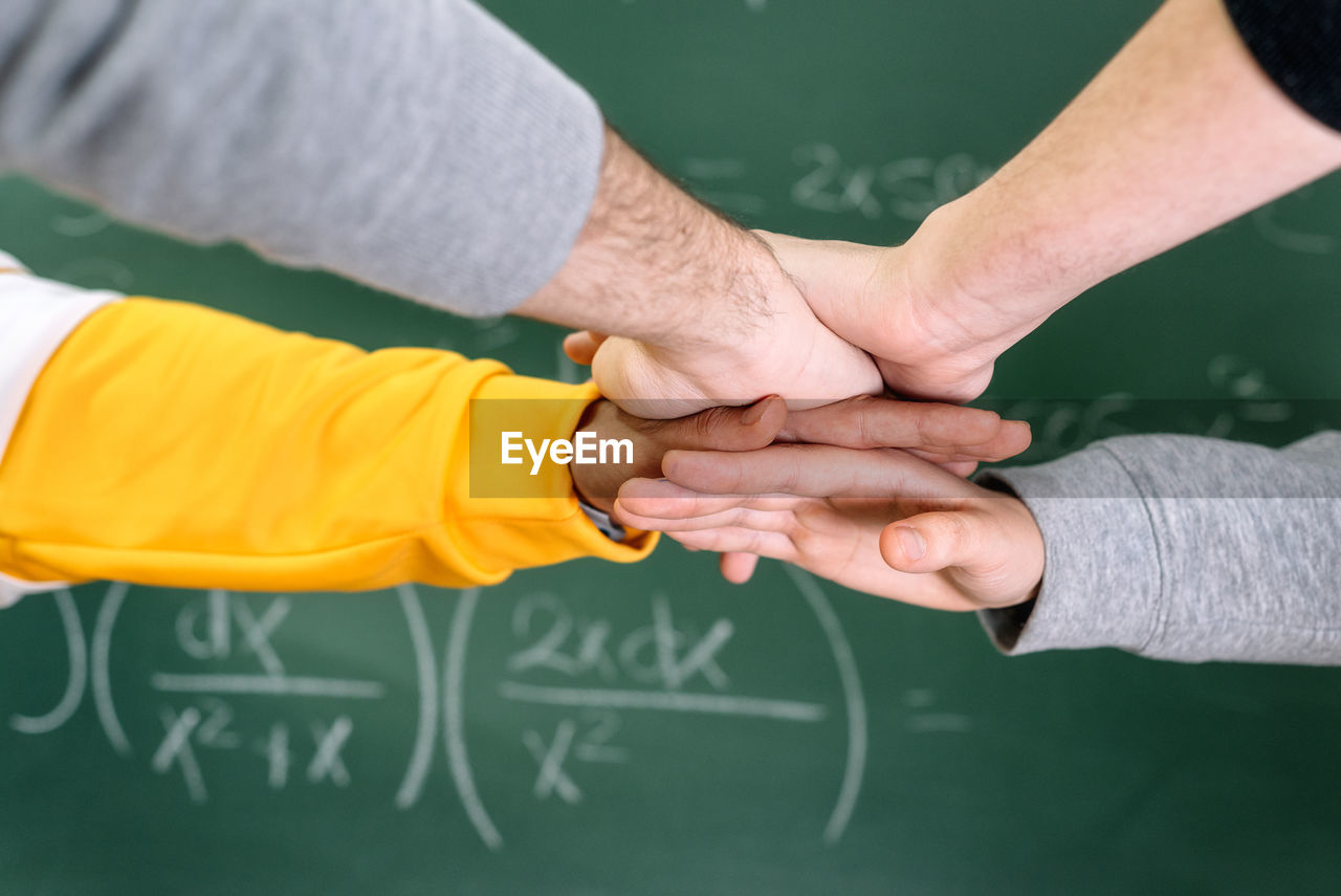 Cropped image of people stacking hands