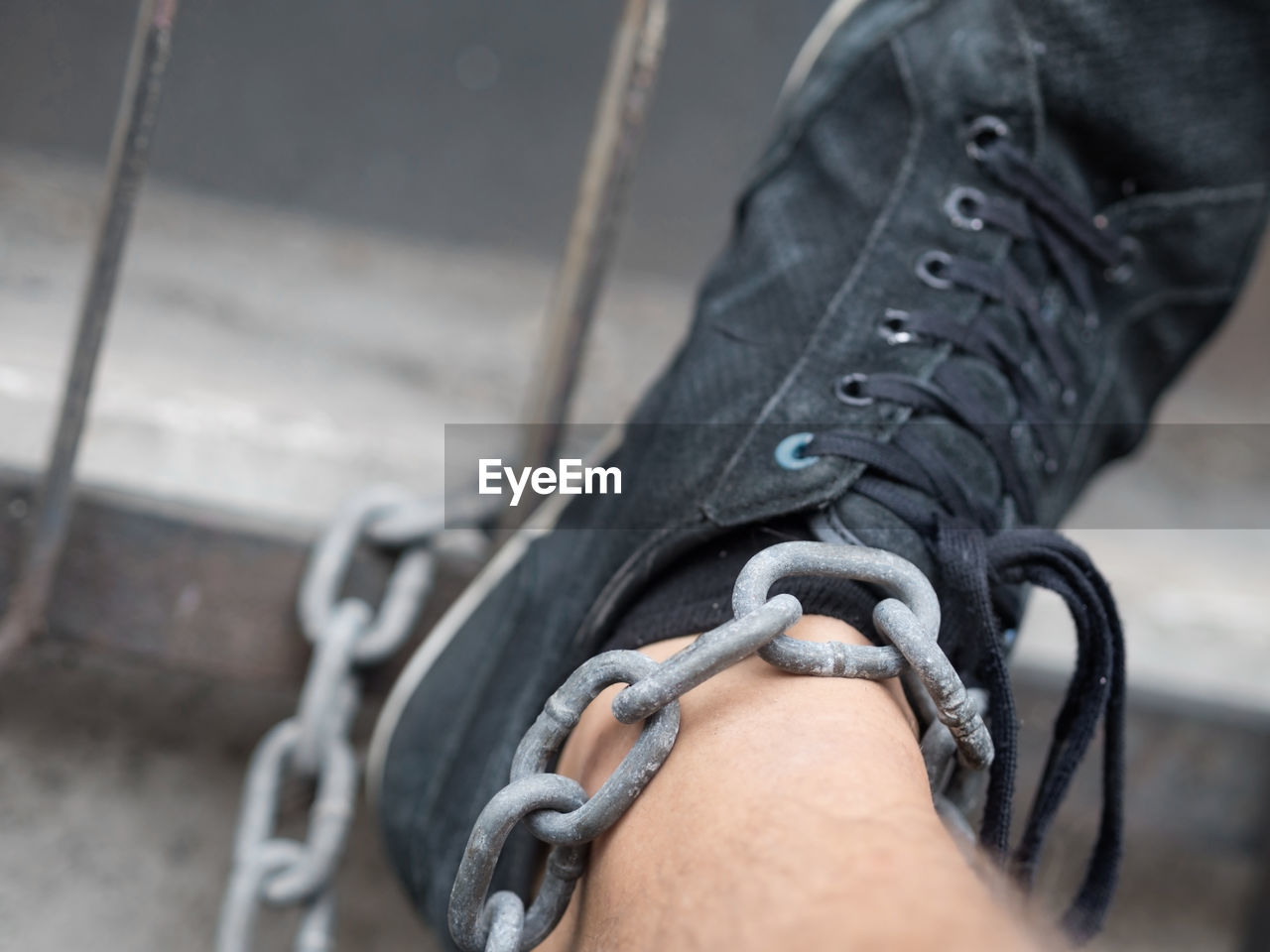 Low section of man in black shoe and chain