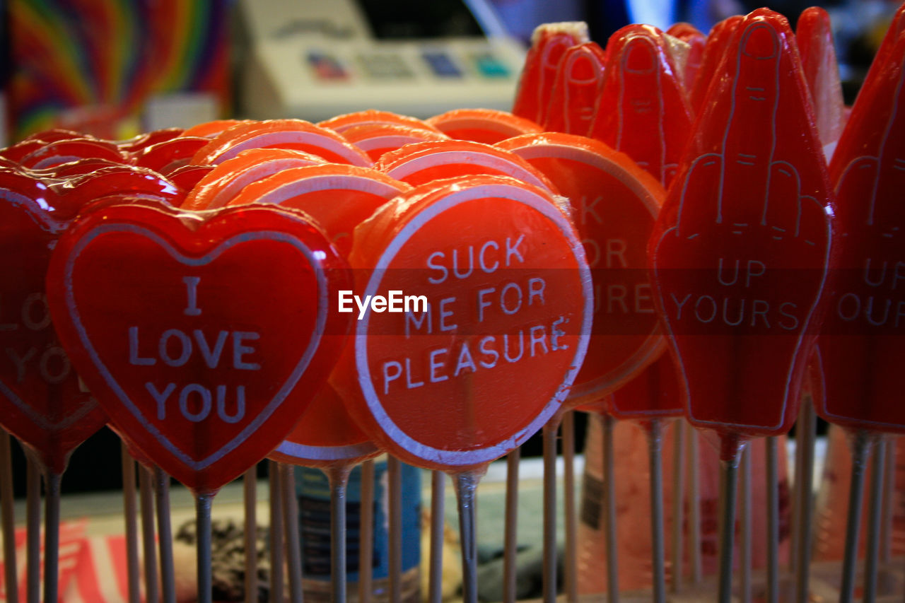 Close-up of red lollipops with text for sale in candy store
