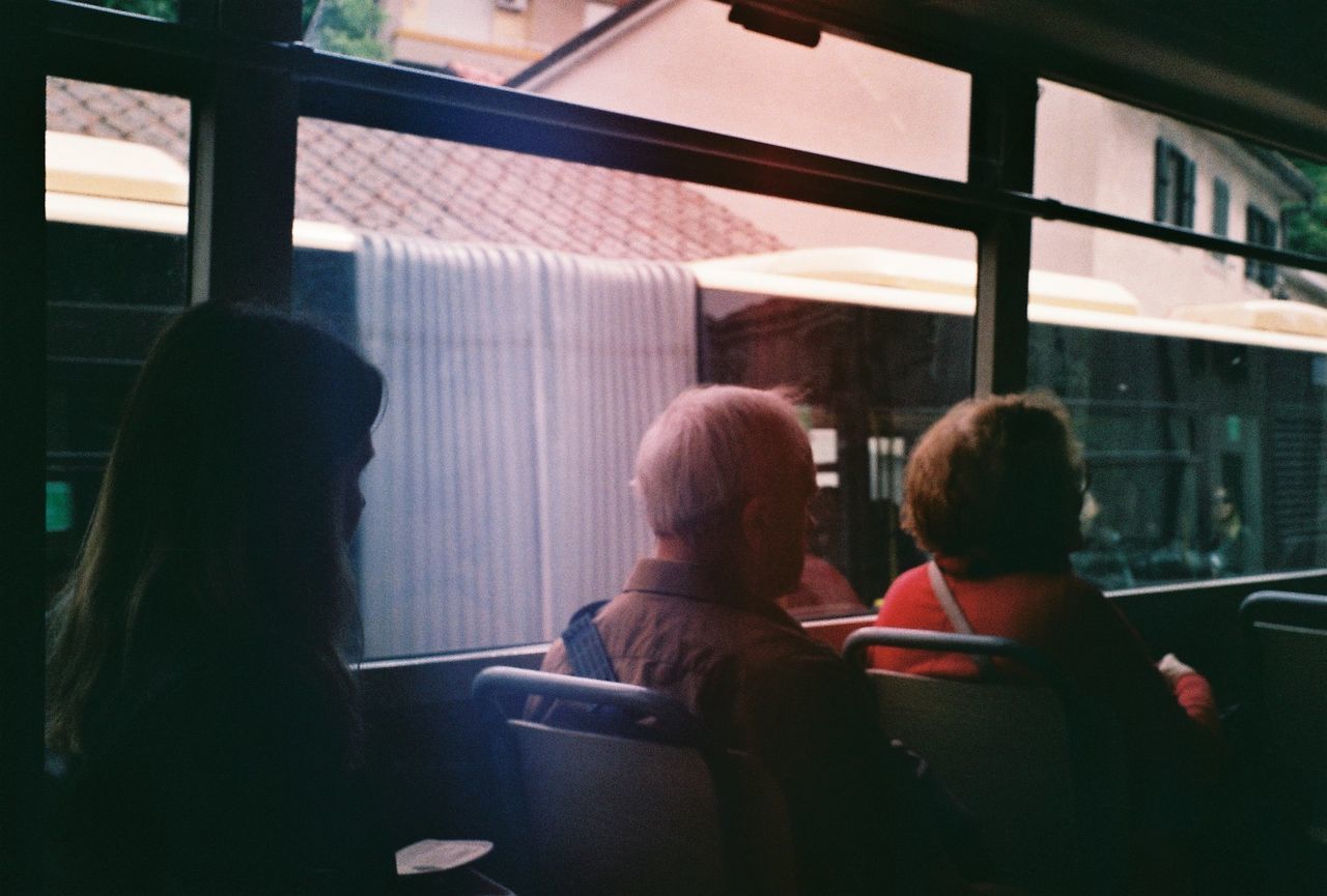 REAR VIEW OF WOMEN SITTING IN BUS