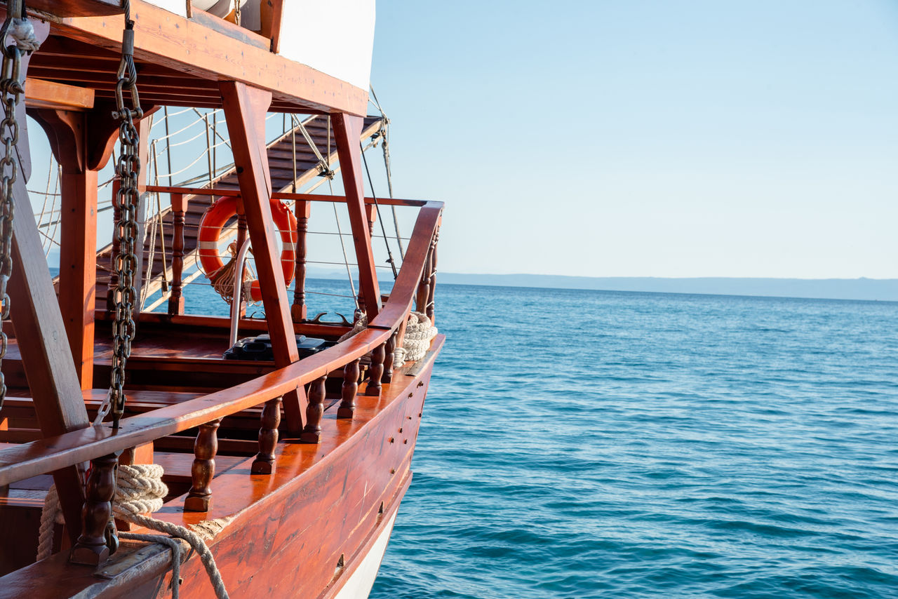 water, sea, nautical vessel, vehicle, transportation, sky, nature, boat, mode of transportation, horizon, clear sky, no people, horizon over water, day, travel, blue, ship, outdoors, scenics - nature, beauty in nature, architecture, watercraft, travel destinations, tranquility, sunlight, sunny, wood, beach