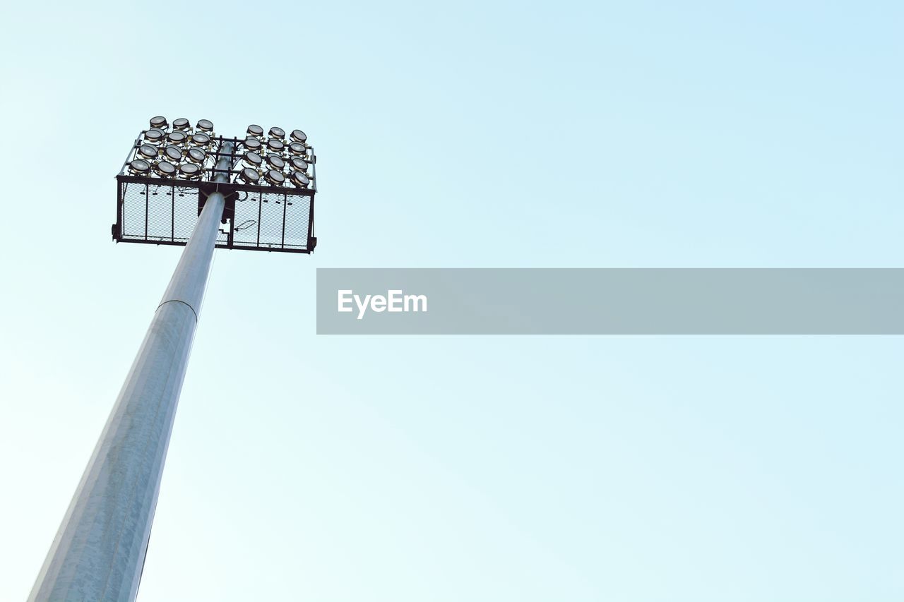 Low angle view of floodlight at stadium against clear sky