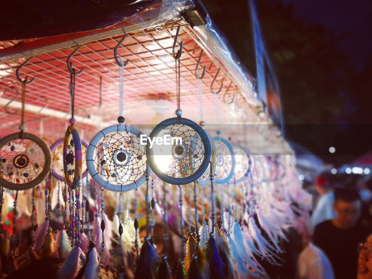 Dreamcatchers hanging at illuminated market at night