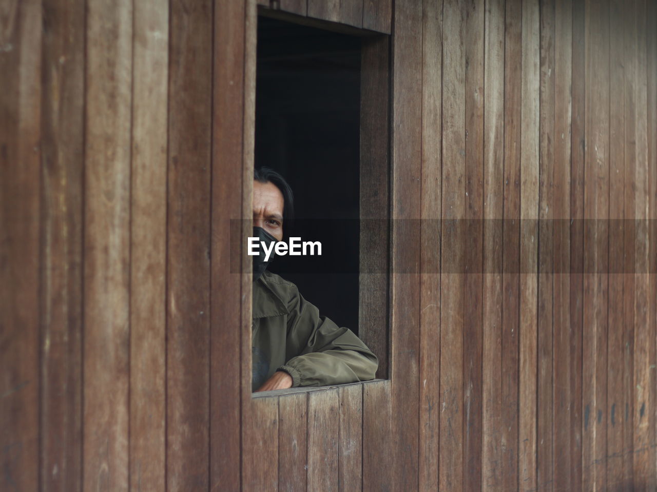 Portrait of man sitting on wooden windows