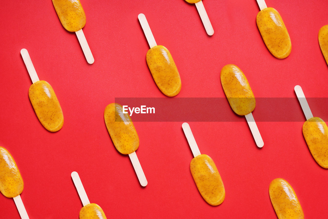Top view passion fruit popsicle or ice lolly or ice pops flat lay pattern on red colored background