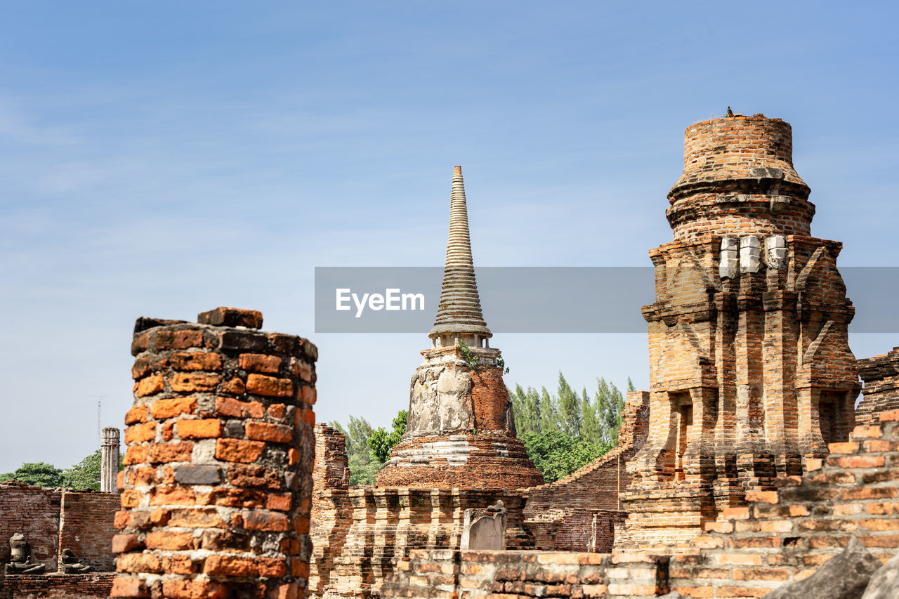 An ancient pagoda in an old temple and a very old brick wall in ayutthaya, thailand.