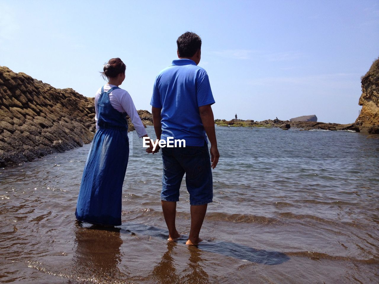 Rear view of couple standing at beach