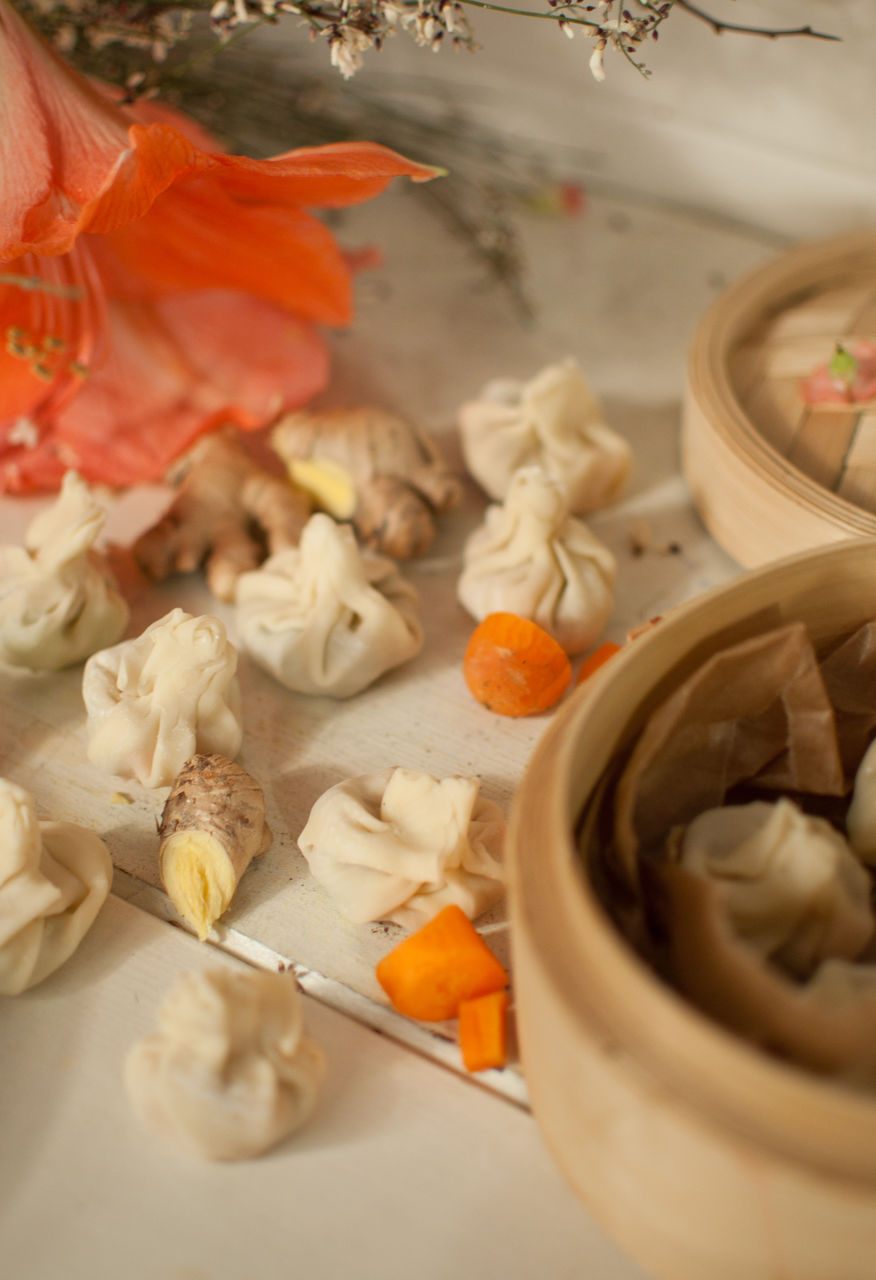 High angle view of dumplings and ginger by container on table
