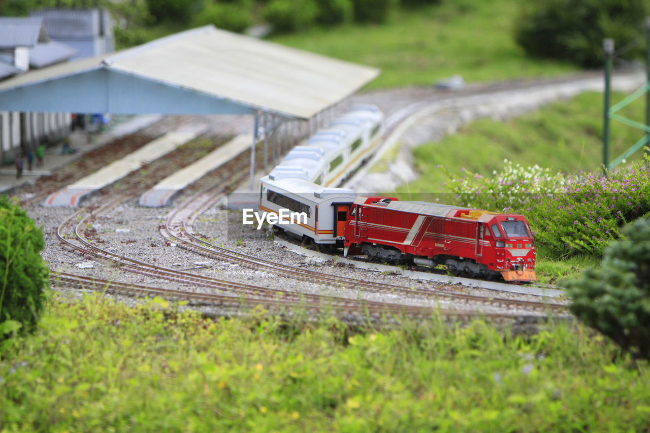 HIGH ANGLE VIEW OF TOY TRAIN ON RAILROAD TRACK