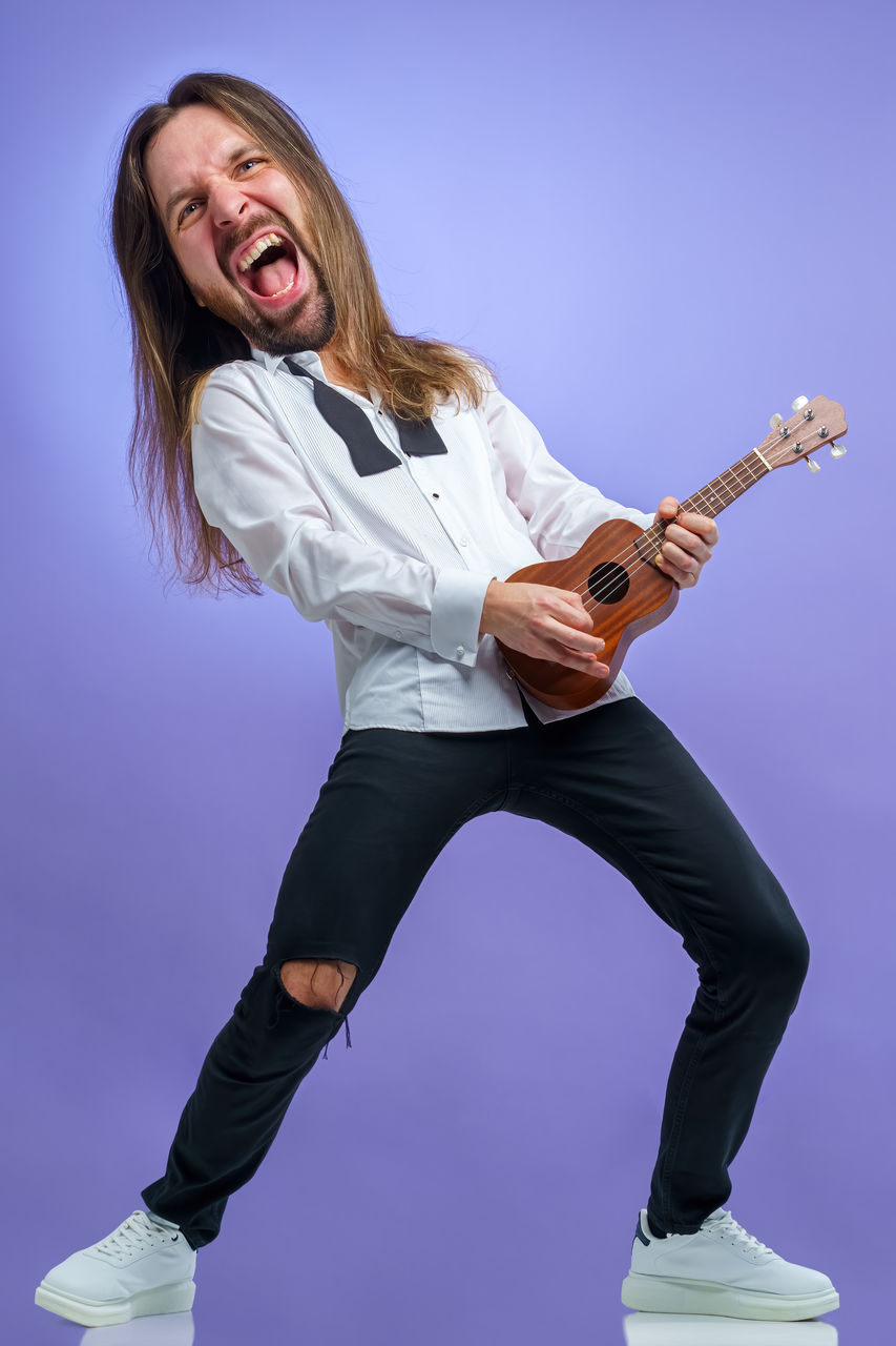 music, one person, arts culture and entertainment, musician, adult, performance, full length, musical instrument, emotion, studio shot, young adult, guitar, mouth open, happiness, string instrument, shouting, women, vitality, portrait, person, long hair, rock music, indoors, positive emotion, human mouth, fun, cheerful, enjoyment, motion, electric guitar, smiling, singing, hairstyle, musical equipment, casual clothing, facial expression, lifestyles, joy, jumping, clothing, female, skill, noise
