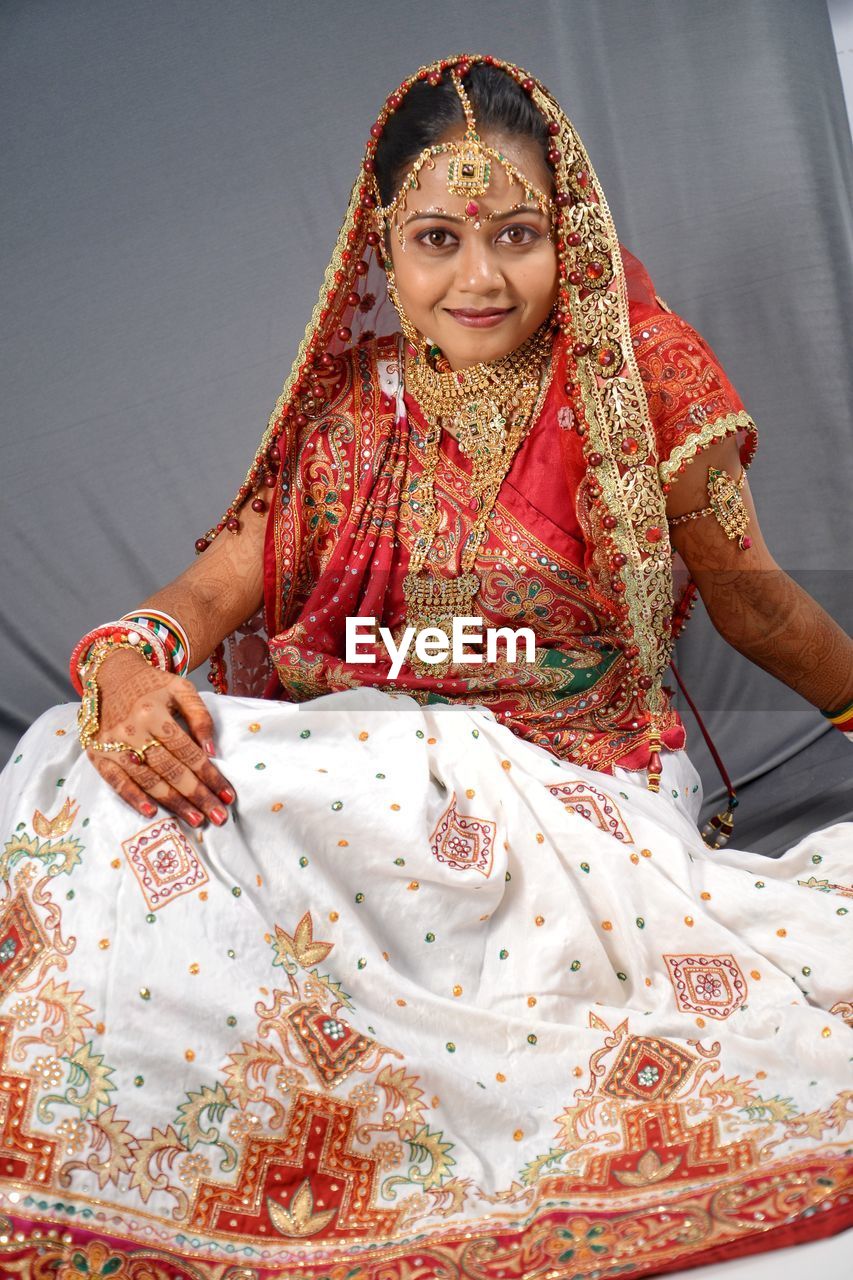 Portrait of beautiful smiling young bride sitting at home