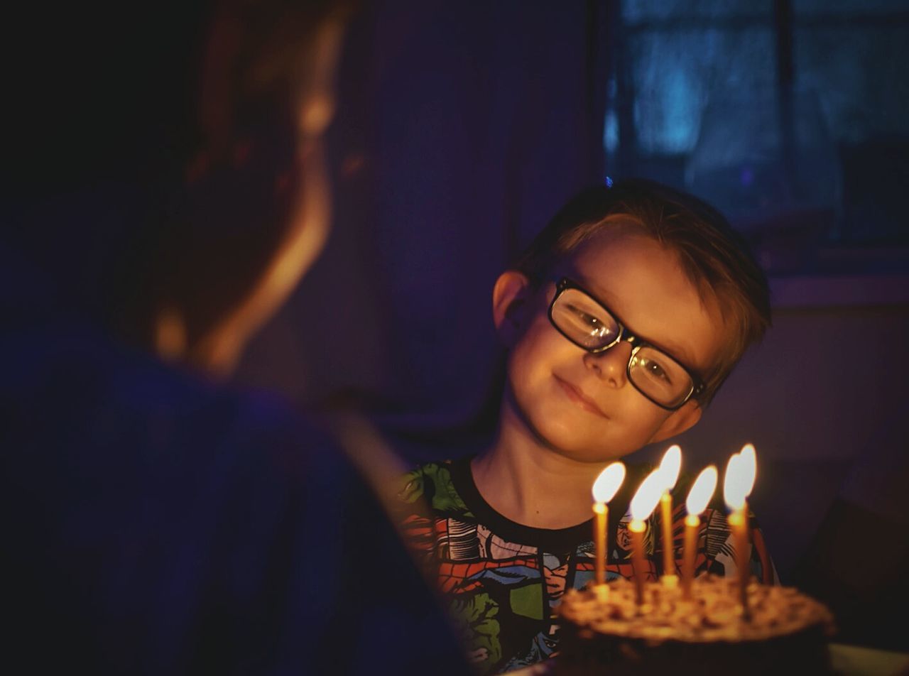 Smiling boy looking at birthday cake