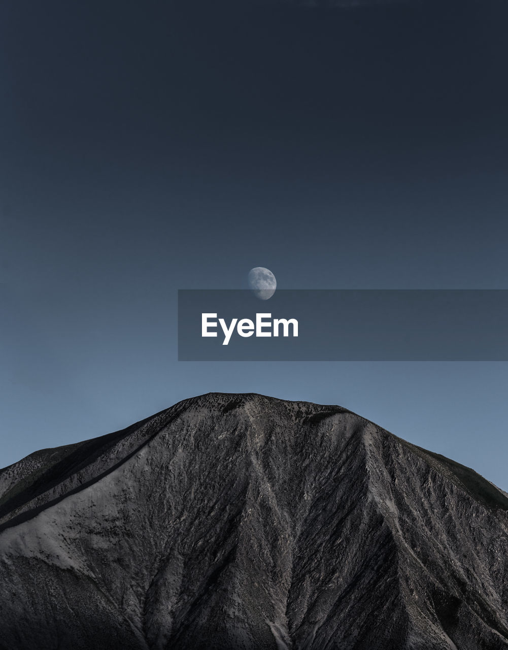 Low angle view of mountain against clear sky at dusk