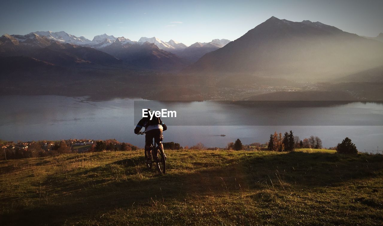Man cycling on mountain by lake at sigriswil