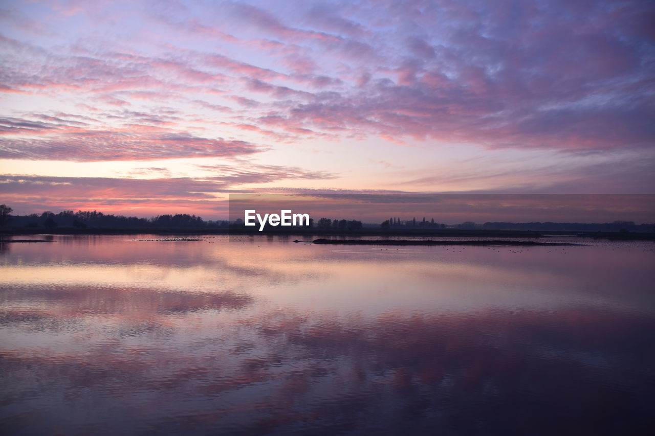 SCENIC VIEW OF LAKE AT SUNSET