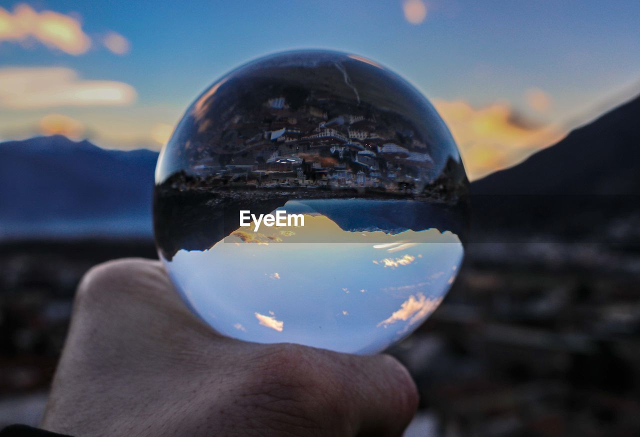 CLOSE-UP OF HAND HOLDING CRYSTAL BALL