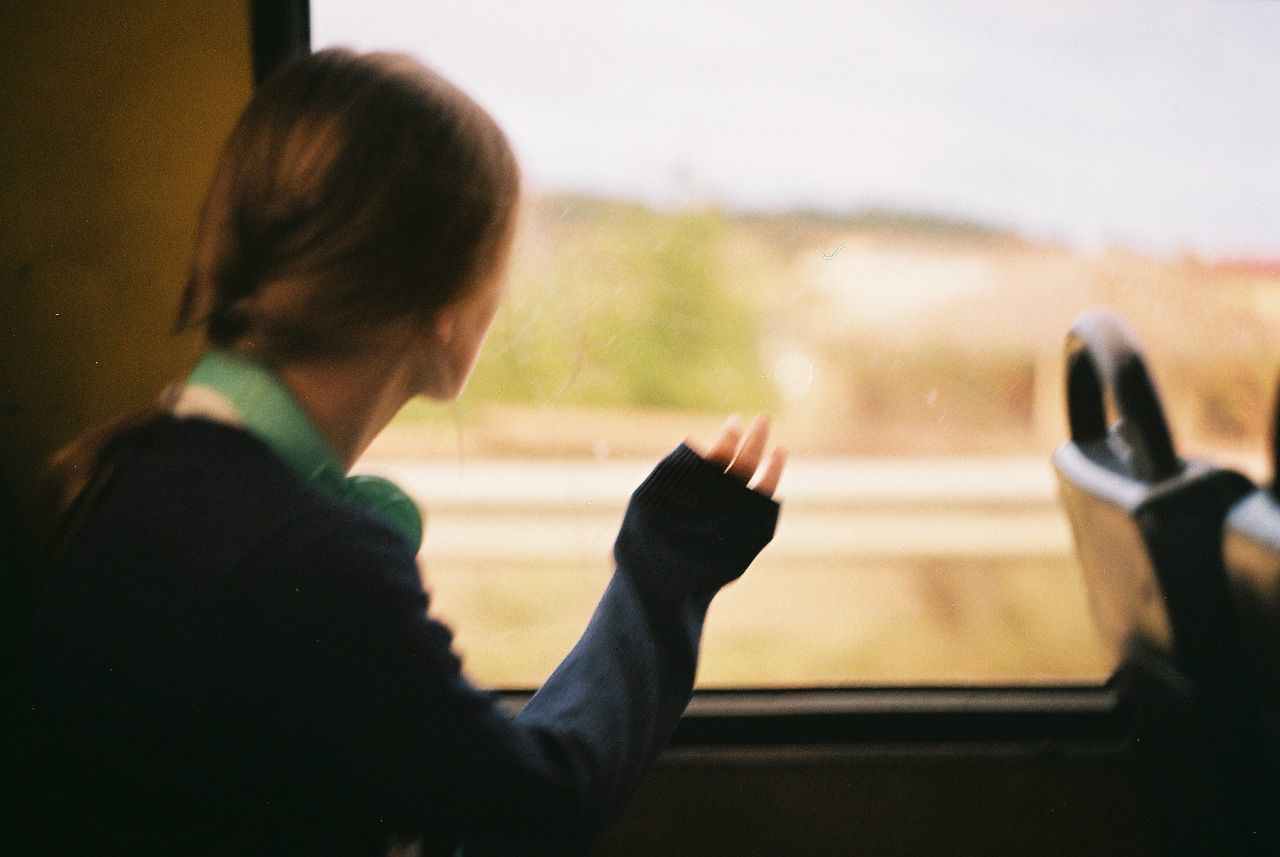 Woman looking through window in train