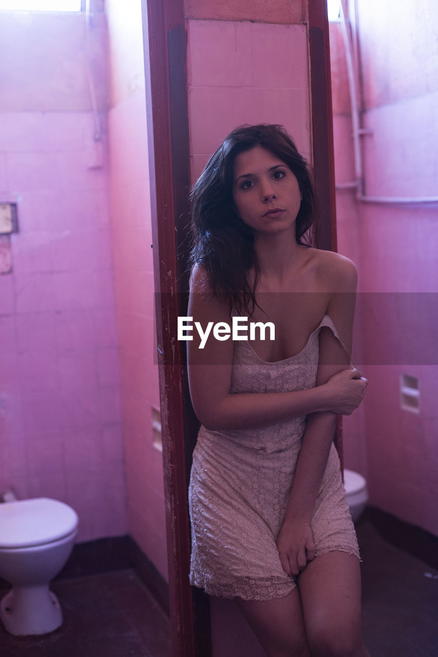 Portrait of sensuous woman standing in public bathroom
