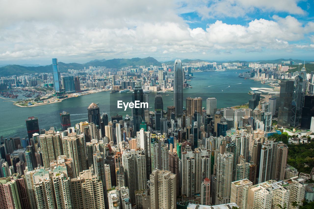 AERIAL VIEW OF MODERN BUILDINGS AGAINST CLOUDY SKY