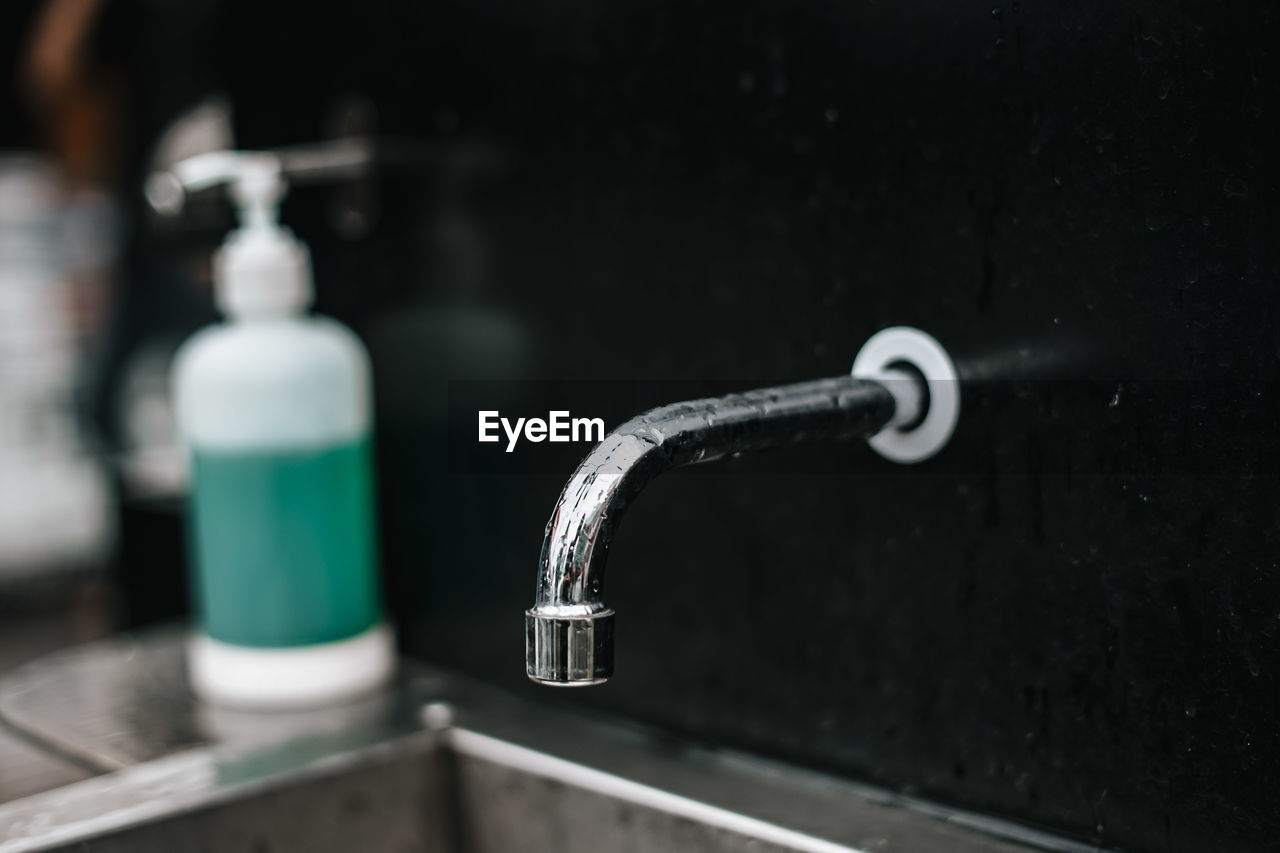 CLOSE-UP OF FAUCET IN GLASS