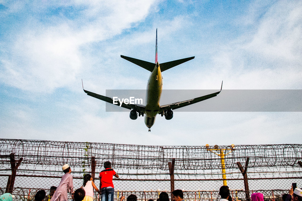 People with airplane flying in sky