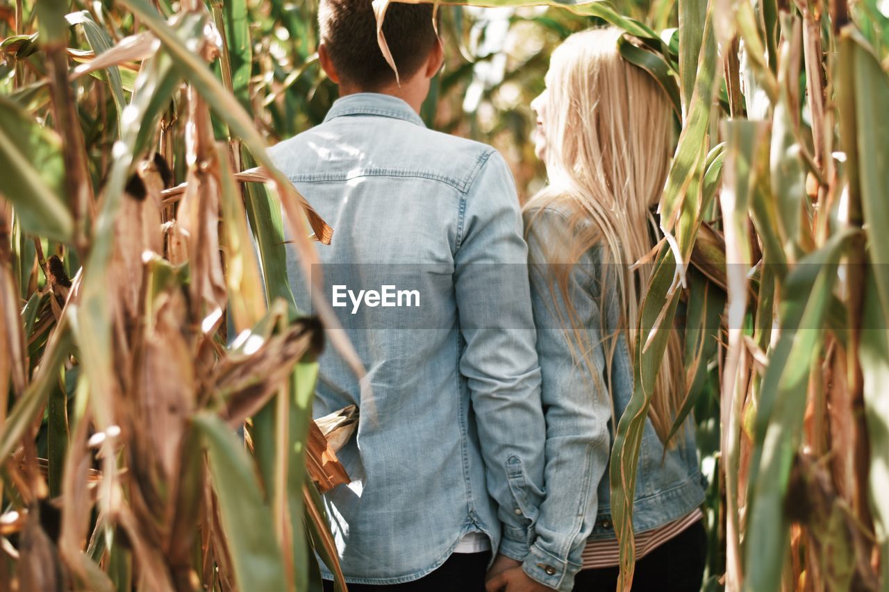 Rear view of couple standing by plants