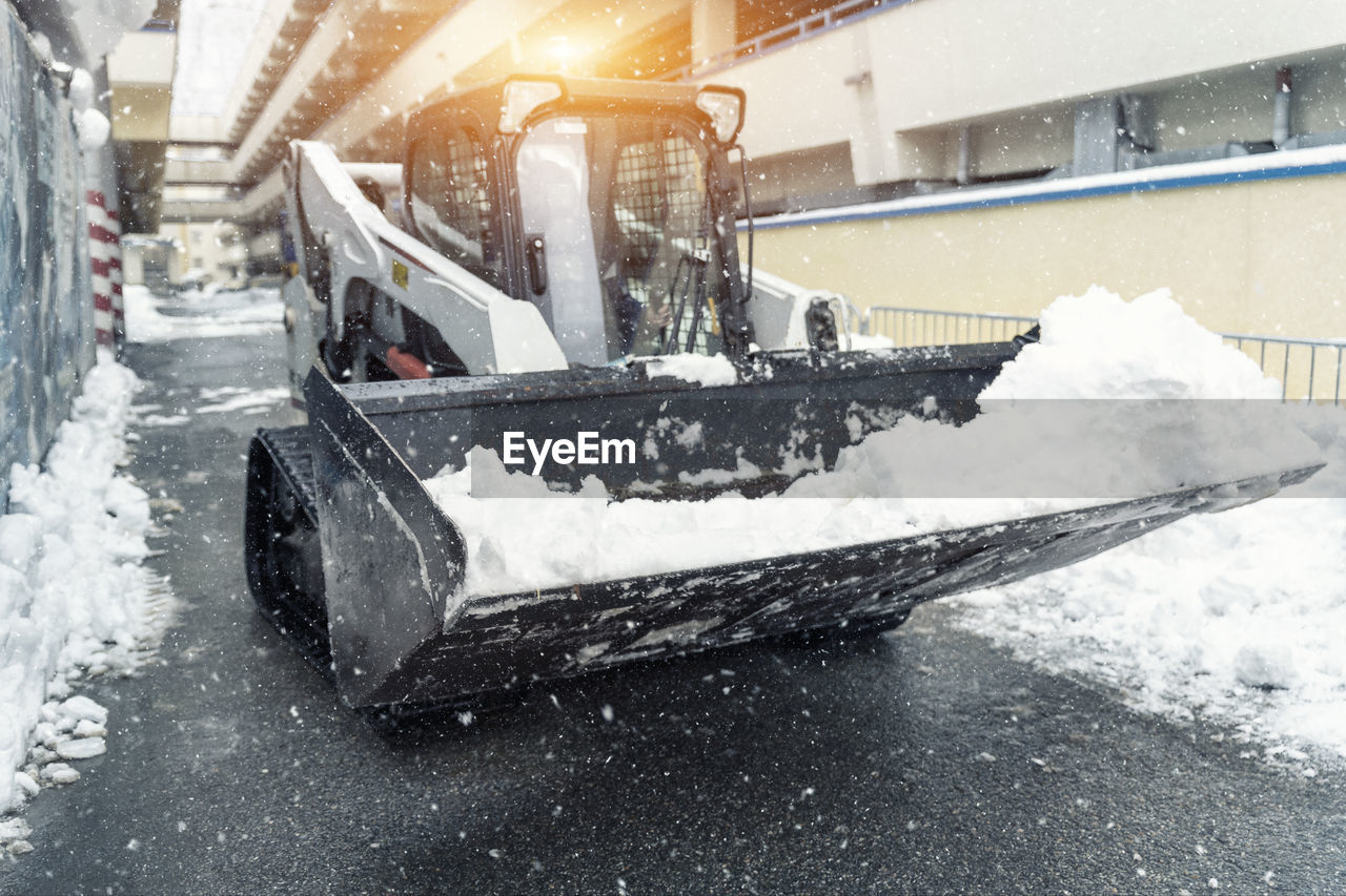 snow, winter, cold temperature, snowplow, snow removal, transportation, architecture, nature, mode of transportation, motion, snow blower, built structure, snowing, frozen, water, freezing, city, blizzard, building exterior, motor vehicle, extreme weather, day, outdoors, vehicle, land vehicle