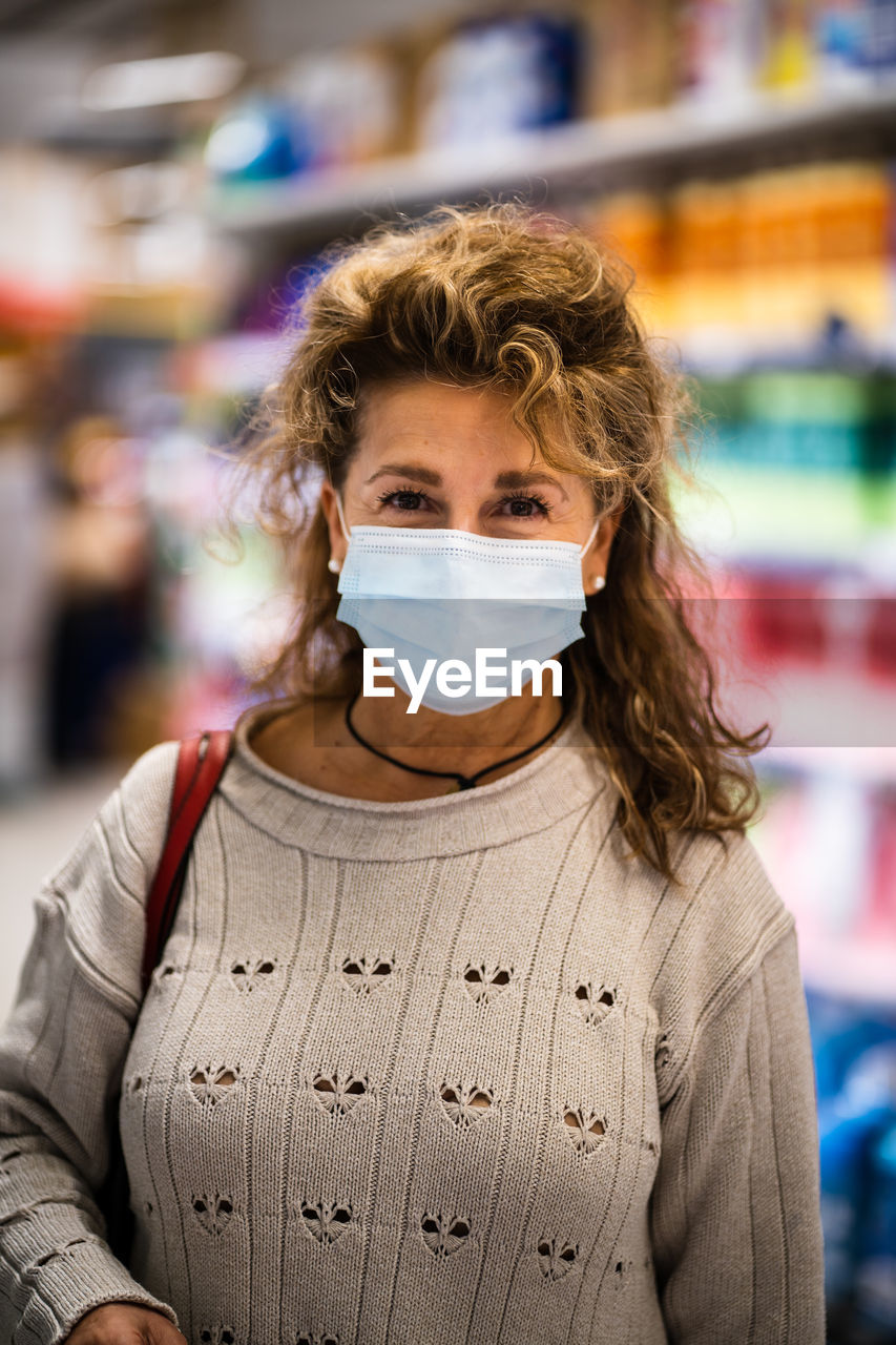 Portrait of woman wearing mask standing in store