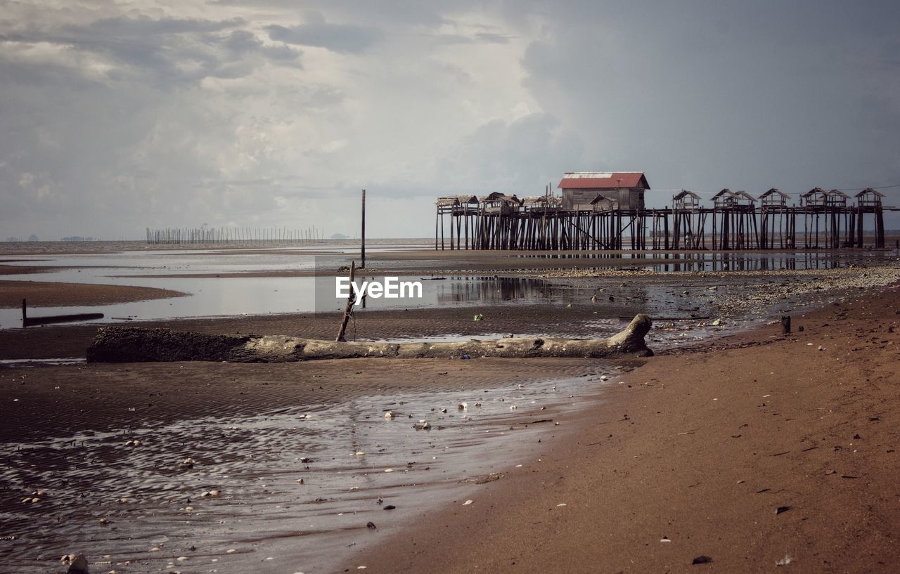 Pier on beach against sky